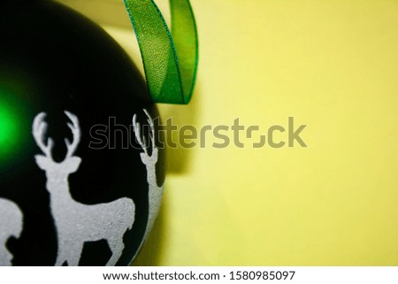 A piece of Christmas green ball with ribbon on a light background