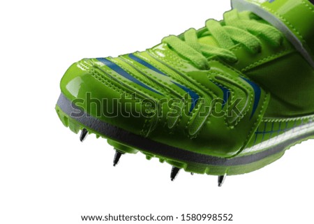 Fragment of a green glossy sneaker with spikes on a white background. Sport shoes.