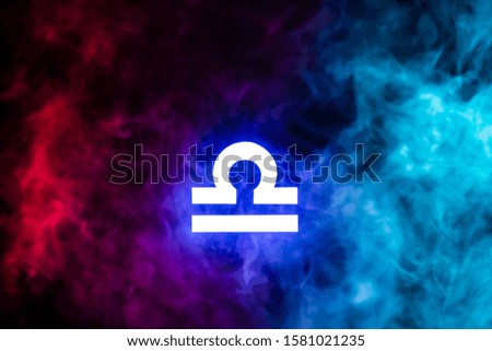 blue illuminated Libra zodiac sign with colorful smoke on background