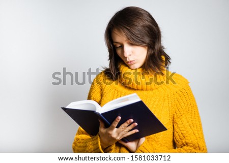 beautiful girl reads a notebook isolated on white background