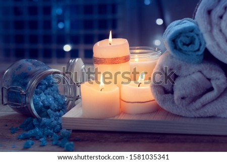 SPA consist from candles, sea salt and  towels on a wooden tray. Picture in Low-key lighting
