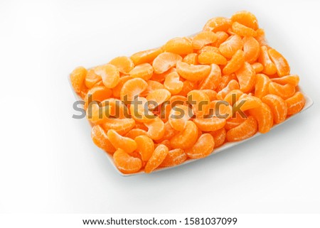 Juicy orange slices of MANDARIN in a rectangular white plate on a white background. Isolate.