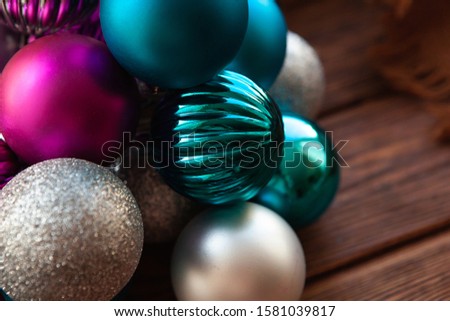 New Year's toys on a wooden surface. New Year's home atmosphere. Blue and pink christmas balls.