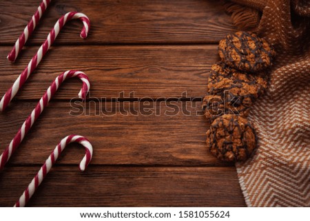 Lollipops in the form of a staff on a wooden surface. Christmas flat lay. Top view with copy space.