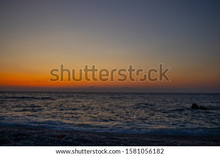 colorful orange sunrise at wavy beach