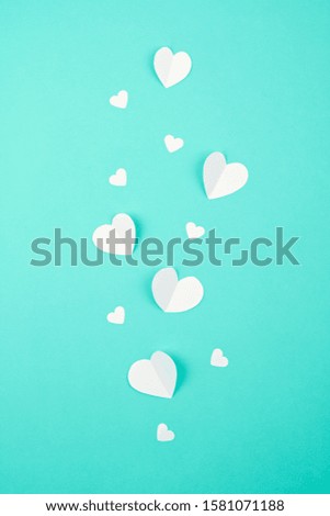 White paper hearts over the tuquiose background. Abstract background with paper cut shapes. Sainte Valentine, mother's day, birthday greeting cards, invitation, celebration concept
