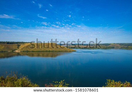 summer time landscape photography of hill land view to horizon shore line district of lake peaceful waters 
