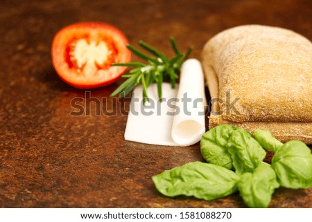 Italian ciabatta and sandwich ingredients. onion, tomato, pepper, goat cheese, razmoin, basil and avocado. Photo