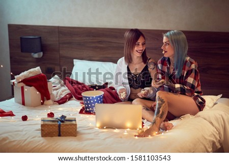 cheerful young girls couple. Couple watch movie at home.