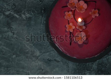 Pink flower cake on grey background.