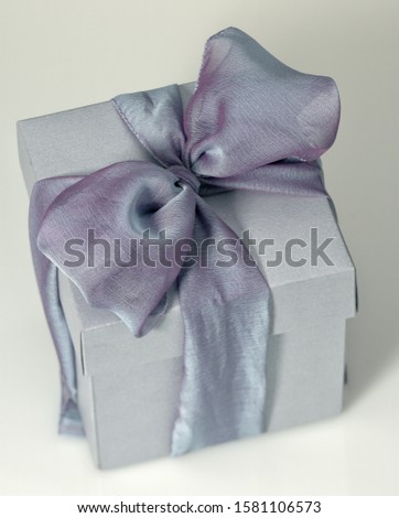 Pic of a grey gift box with a big ribbon and bow	
