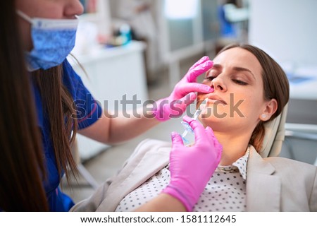 Female increases lips with injection in beauty salon
