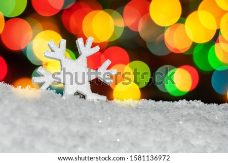 figure snowflakes in the snow. with colorful Christmas round the side bokeh