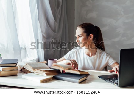 girl works at the computer reads books