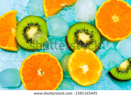 Fresh fruits background.Slices of fresh fruits top view on ice. orange and kiwi slices, fresh summer background banner.