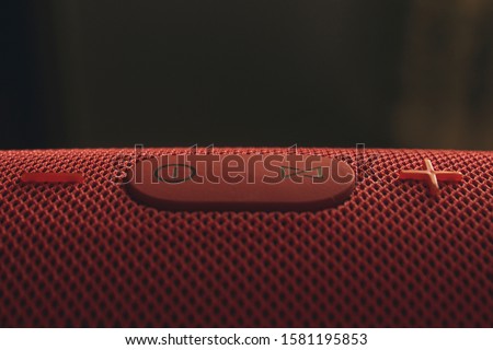 Wireless music column. Red wireless speaker with bass. Control and volume buttons.
