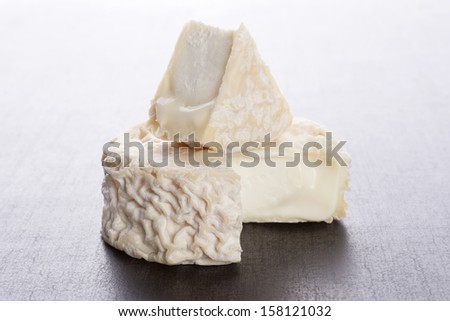 Delicious goat cheese on dark grey background. Culinary cheese eating. 