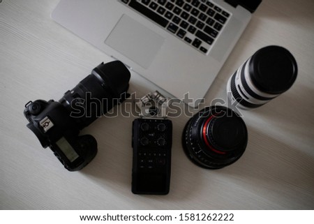 Laptop on the table with camera, recorder, photography and cinema lens