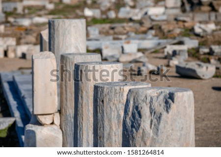 Closeup stone gray ancient pillars perspective, sunlighted blurred ancient city ruins background