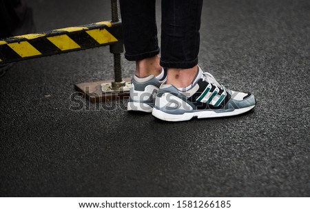 Young fashion people legs in jeans and boots on white floor, wooden floor. Fashionable clothes Royalty-Free Stock Photo #1581266185