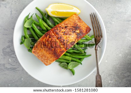 Grilled blackened salmon served with green beans and lemon Royalty-Free Stock Photo #1581281080