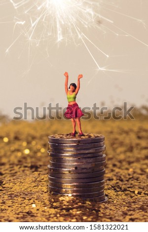 Woman in pile of gold. Miniature girl is happy with her savings, wealth, earnings, or finance. Winning a big jackpot. Money goals for 2020. Big spender or high roller.