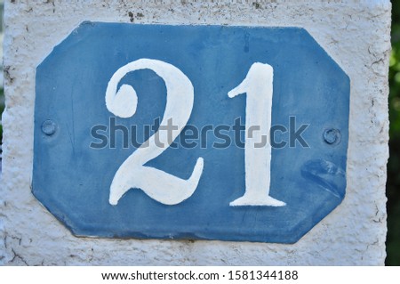 A house number plaque, showing the number twenty one (21)