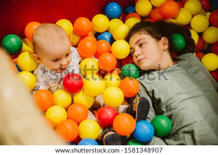 Baby boy and girl lying in colorful balls