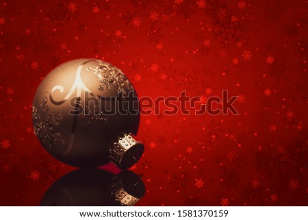 Gold christmas ball in red background with snowflakes.