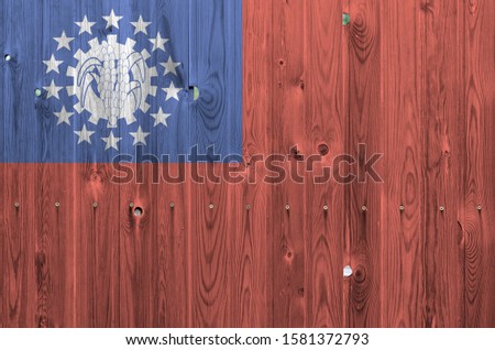 Myanmar flag depicted in bright paint colors on old wooden wall. Textured banner on rough background