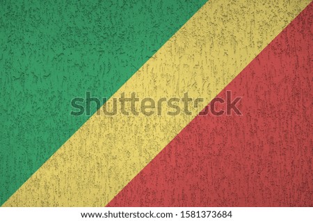 Congo flag depicted in bright paint colors on old relief plastering wall. Textured banner on rough background