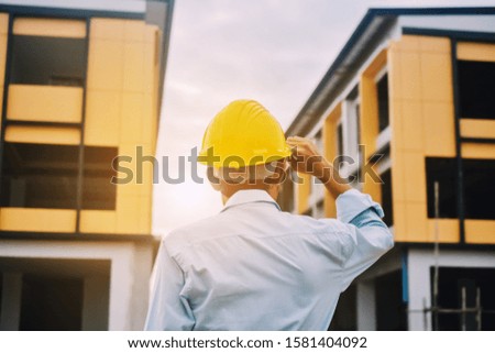 Foreman construction project control holding hard hat safety at estate building 