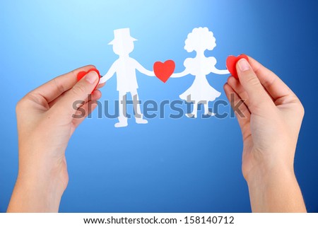 Paper people in hands on blue background