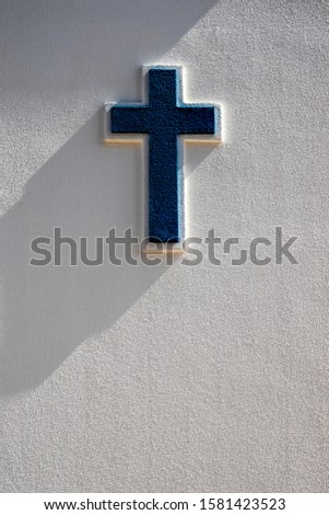 embossed blue painted cross on a white wall
