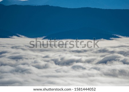 Carpathian mountains in the waves of fog in the fall