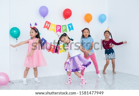 Adorable Asian schoolkids group enjoy the birthday party at home with many gift boxes, happy children boys and girls eating bakery doughnuts  and drink juice together with cheerful in recreation party