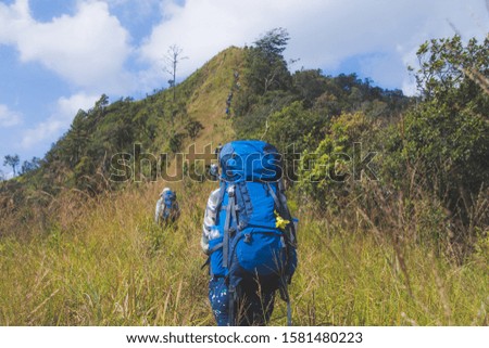 young woman backpacker hiking on mountain peak, subject is blurred. selected focus