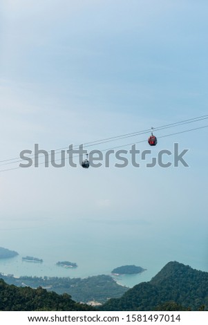 A picture of two cabins riding the steepest cable car in the world located in Langkawi, Malaysia. Also known as Skycab, this unique means of transport links Teluk Burau and Gunung Machinchang.