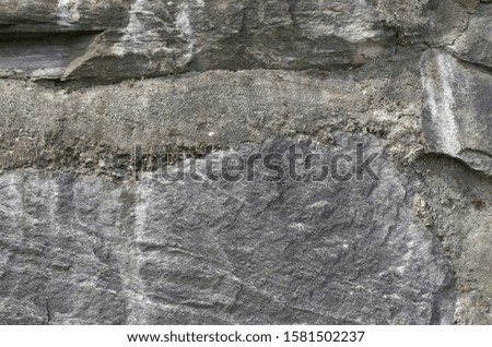 Wall in massive rock and cement