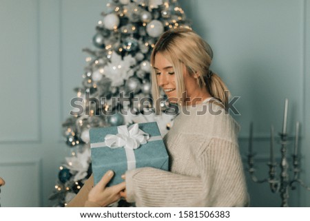 Happy couple giving presents for Christmas at home. Lovely christmas couple holding presents.