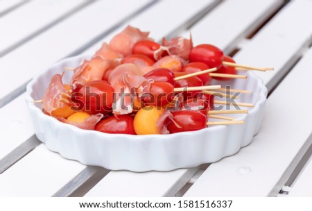 close up of appetizer make from red tomatoes, ham and yellow melon for party and special occasion. 