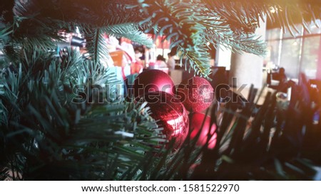 Red Christmas ball on Christmas tree. Horizontal image close up and selective focus red wrinkle Cristmas ball hanging on Cristmas tree for celebrate.