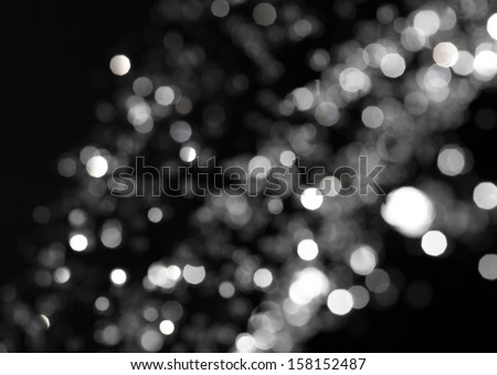Bokeh lights on black background, shot of flying drops of water in the air, defocused water drops levitation on dark, blurred