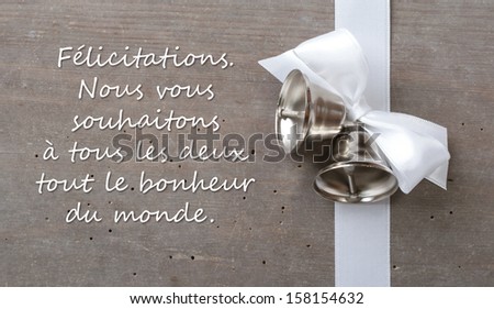 wedding card with white bow and bells/Congratulations. Wishing the both of you all the happiness in the world./french