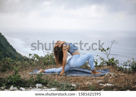 Girl practice yoga near ocean