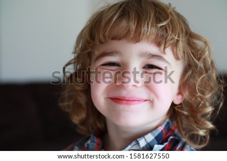 Cute little boy smiling up close portrait. Professional picture with background blurred out, main subject is in focus.