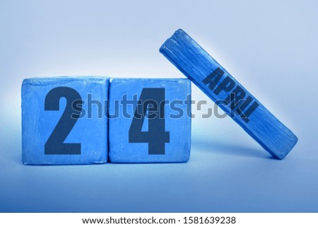april 24th. Day 24 of month, Handmade wood cube calendar with date month and day in trendy classic blue color of the year spring month, day of the year concept