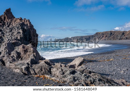 black beach of Djupalonsandur with black sand and huge lava rock monoliths eroded by the atlantic surf , sanefellsness peninsula, western Iceland
