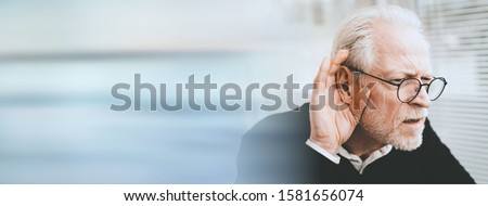 Portrait of senior man having hearing problems; panoramic banner Royalty-Free Stock Photo #1581656074