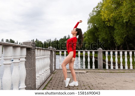 Beautiful girl athlete doing stretching in the park
